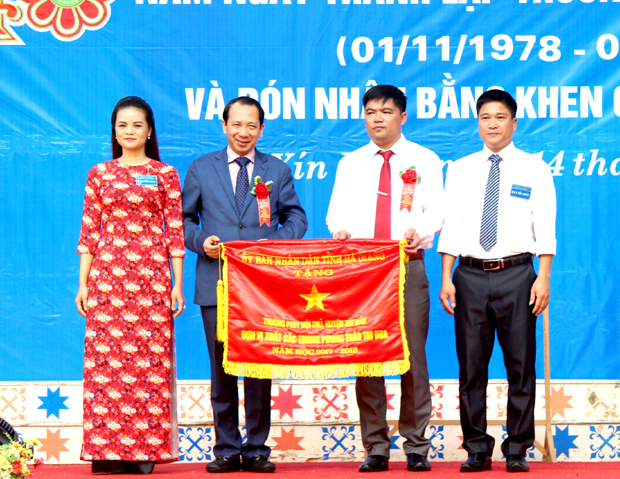 Phó Chủ tịch UBND tỉnh Trần Đức Quý trao Cờ Thi đua của UBND tỉnh cho nhà trường.