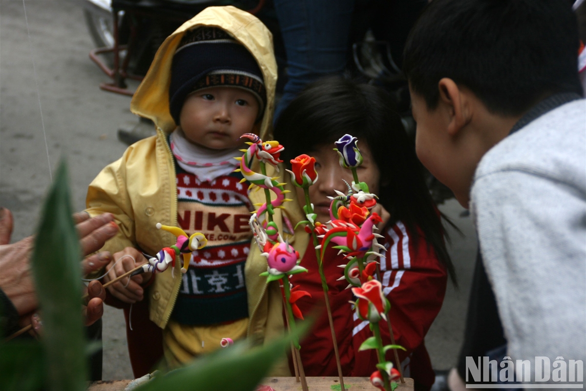 Em bé đi chơi chợ Tết làng Mọc Quan Nhân. (Ảnh: TUYẾT LOAN)
