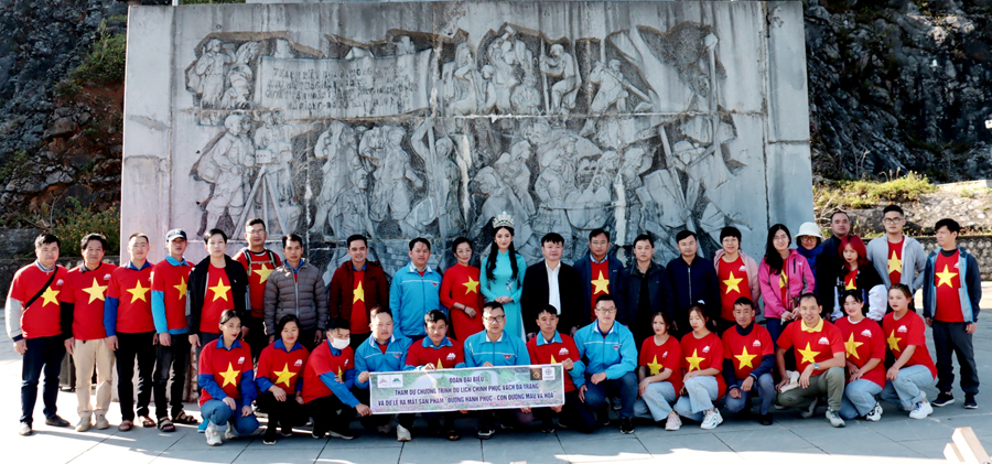Du khách chụp ảnh lưu niệm dưới chân Tượng đài Thanh niên xung phong, xã Pải Lủng.
