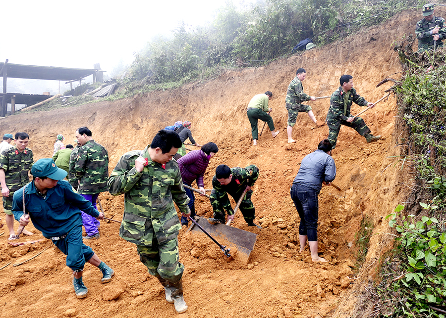 Cán bộ, chiến sỹ lực lượng vũ trang huyện Hoàng Su Phì giúp người dân san nền, làm nhà ở. 				Ảnh: PHI ANH