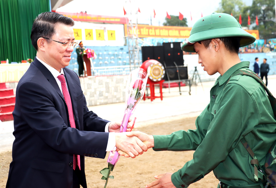 Trưởng Ban Dân vận Tỉnh ủy Trần Mạnh Lợi tặng hoa, động viên các tân binh lên đường nhập ngũ.
