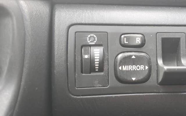 Nút chỉnh độ sáng bảng đồng hồ táp-lô (trái) bên cạnh cụm nút chỉnh gương.