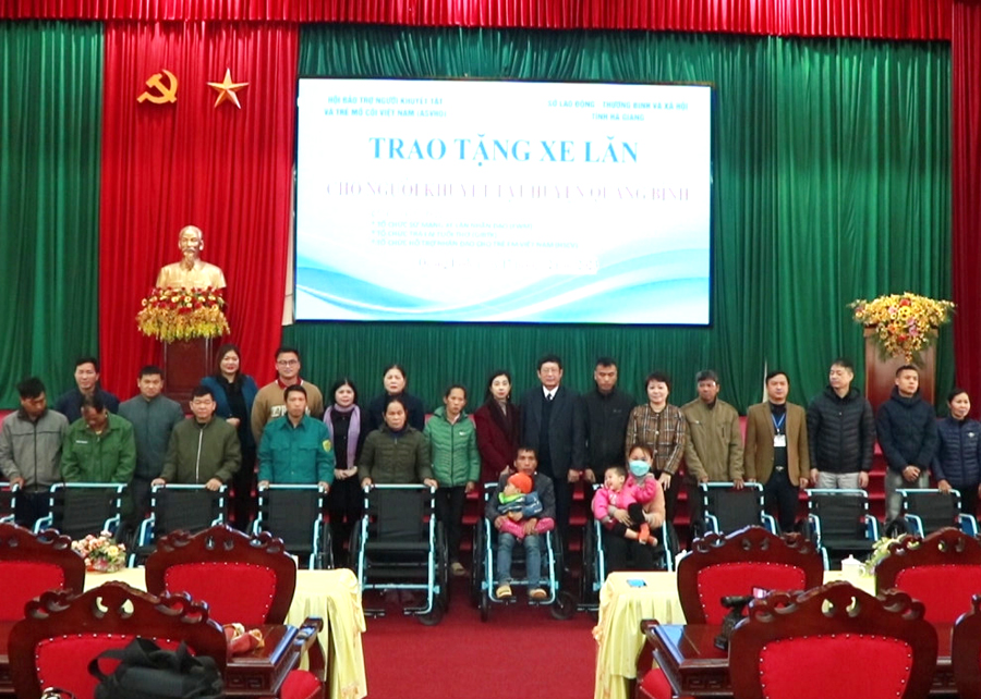 Đại diện các đơn vị trao tặng xe lăn cho người khuyết tật huyện Quang Bình.
