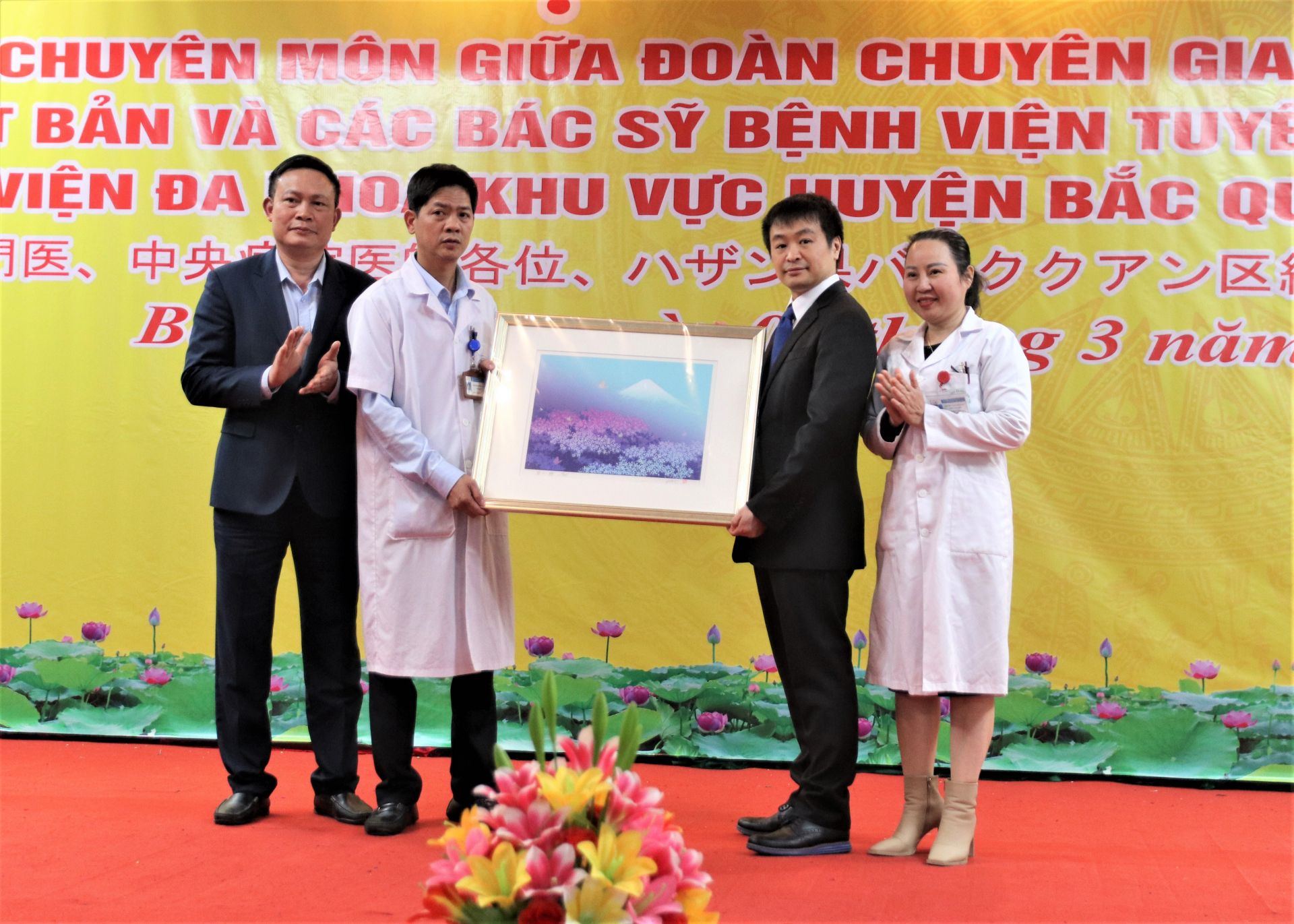 Tiến sĩ, Bác sĩ Matsuoka Yoshinori tặng bức tranh Hoa Anh đào và núi Phú Sĩ – biểu tượng của Nhật Bản cho lãnh đạo Bệnh viện ĐKKV huyện Bắc Quang.
