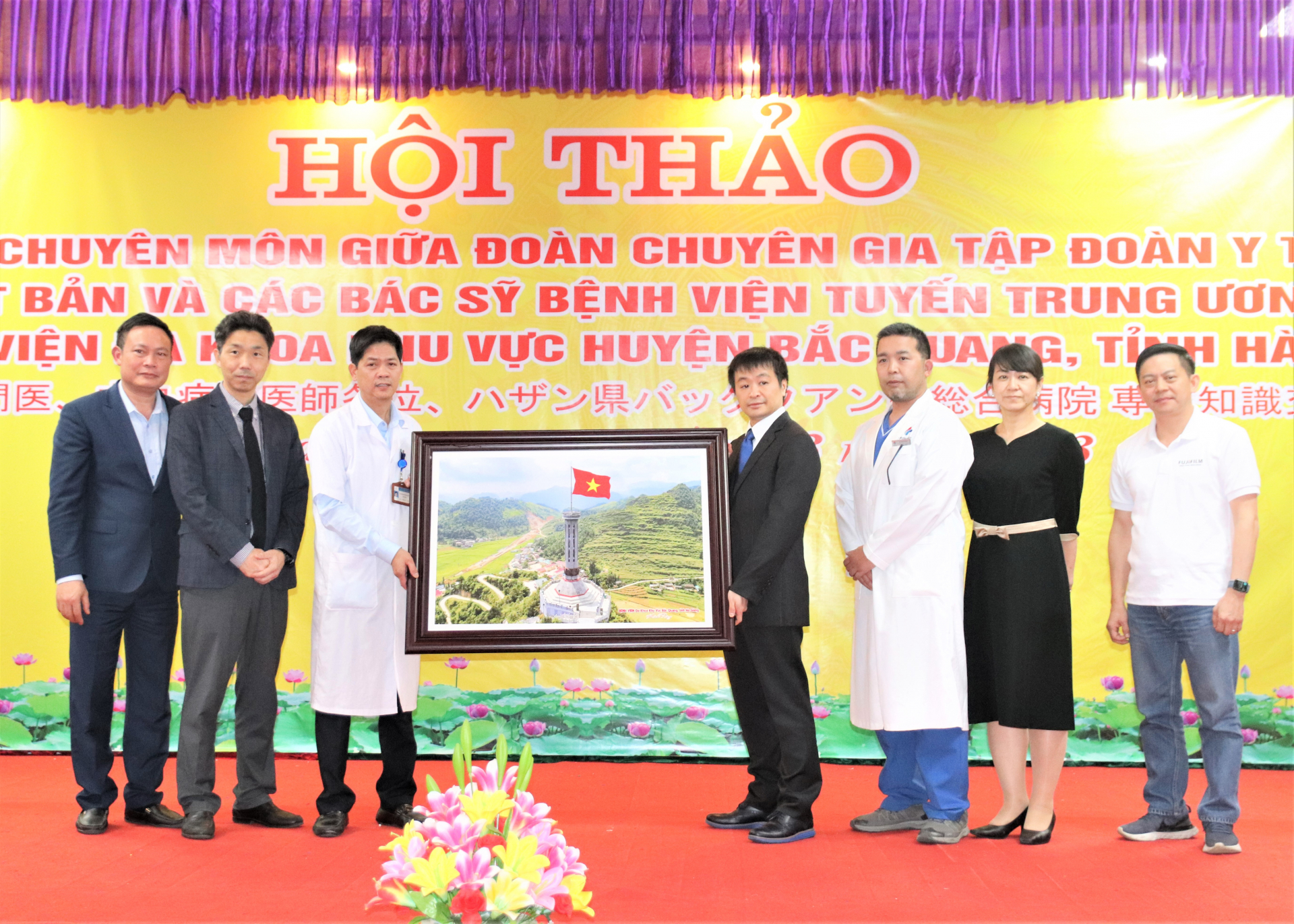 Lãnh đạo Bệnh viện ĐKKV huyện Bắc Quang tặng bức tranh Cột cờ Lũng Cú (Hà Giang) cho đoàn chuyên gia của Tập đoàn Y tế EMS Nhật Bản.