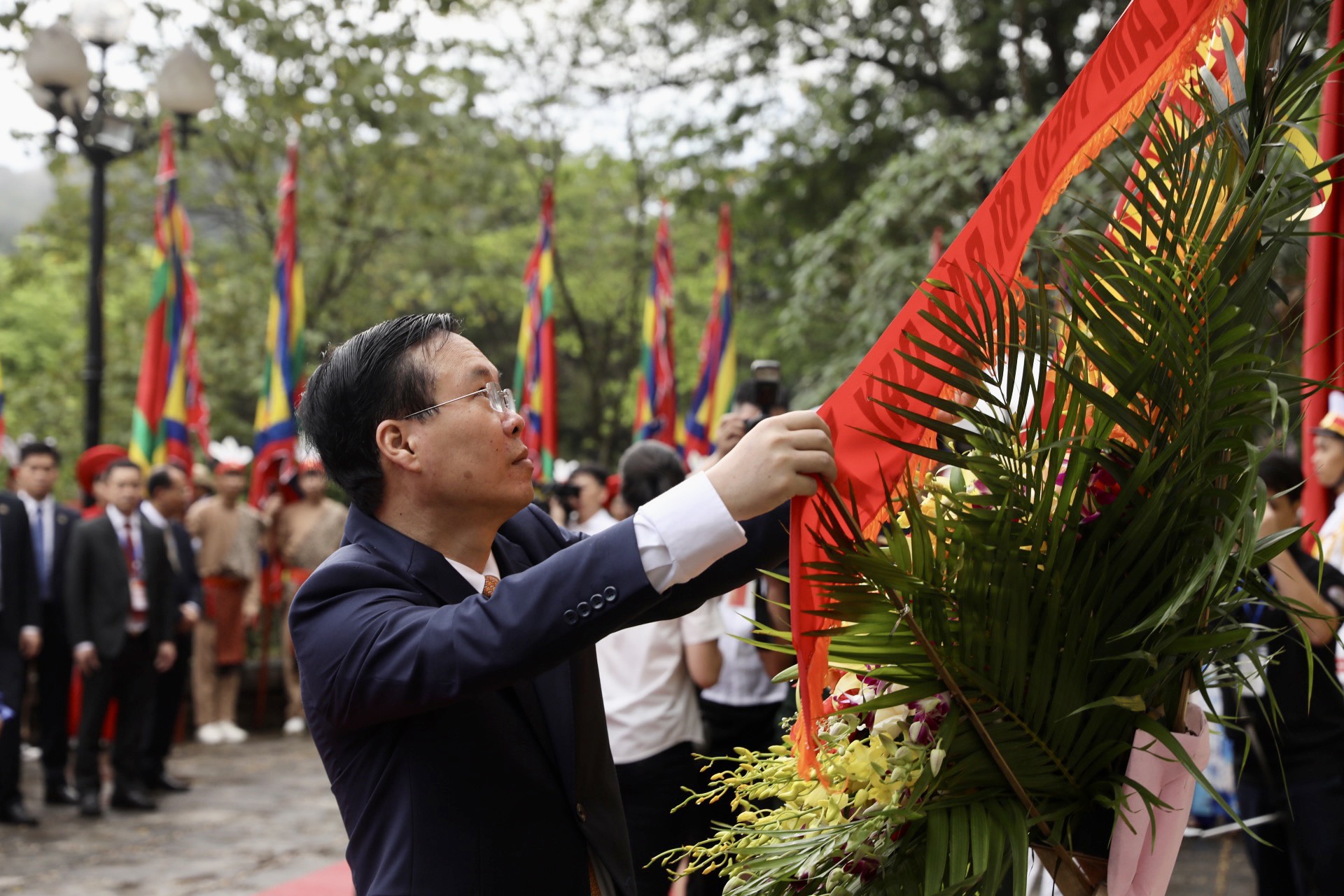 Chủ tịch nước Võ Văn Thưởng chỉnh dải băng trên vòng hoa tại bức phù điêu Bác Hồ nói chuyện với Đại đoàn quân tiên phong.