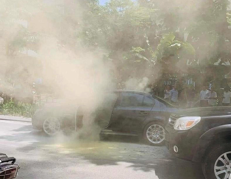 Chiếc BMW bị bốc khói mù mịt khi đỗ dưới trời nắng tại phố Huỳnh Thúc Kháng (Hà Nội) vào ngày 17/5. 
