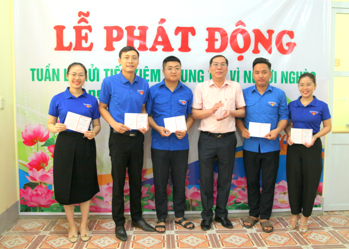 Lãnh đạo Phòng Giao dịch Ngân hàng CSXH huyện Yên Minh trao sổ tiết kiệm cho các cá nhân.
