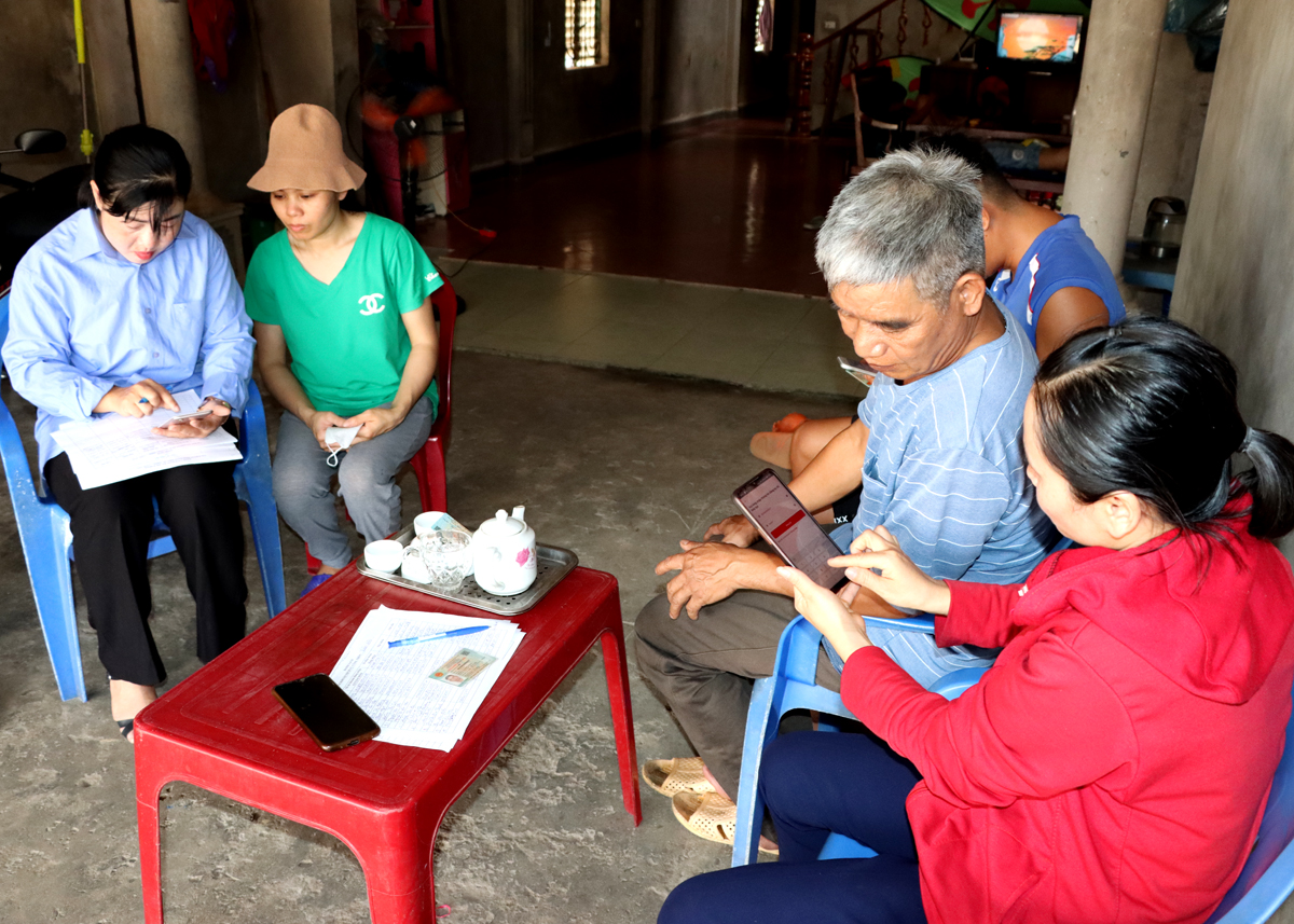 Thành viên Tổ công nghệ số cộng đồng xã Tân Quang hướng dẫn người dân thôn Xuân Hòa thực hiện các giao dịch trên điện thoại thông minh.