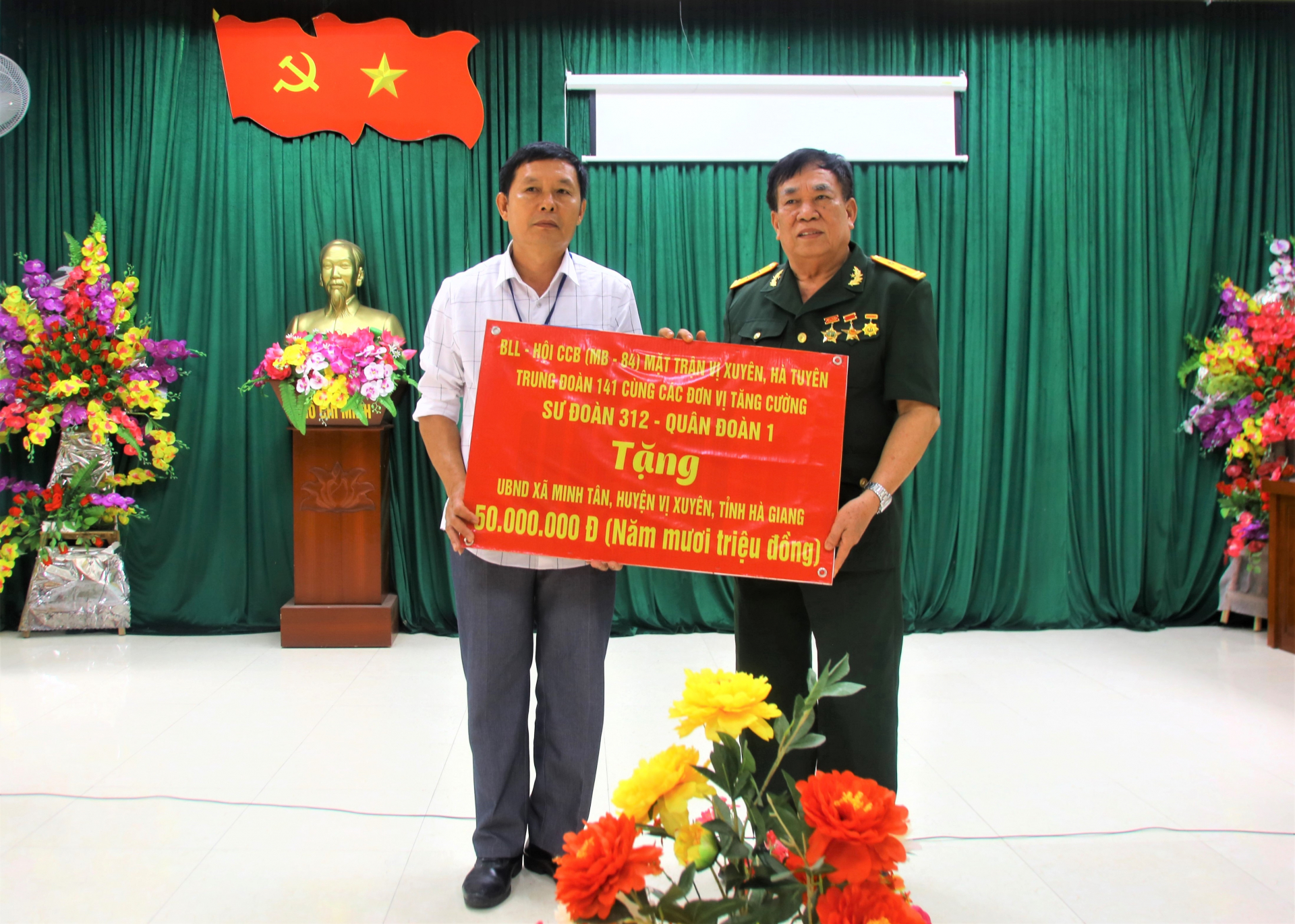 Ban liên lạc Hội CCB Trung đoàn 141 mặt trận Vị Xuyên trao tiền ủng hộ xây dựng Đền thờ tưởng nhớ các AHLS cho UBND xã Minh Tân.