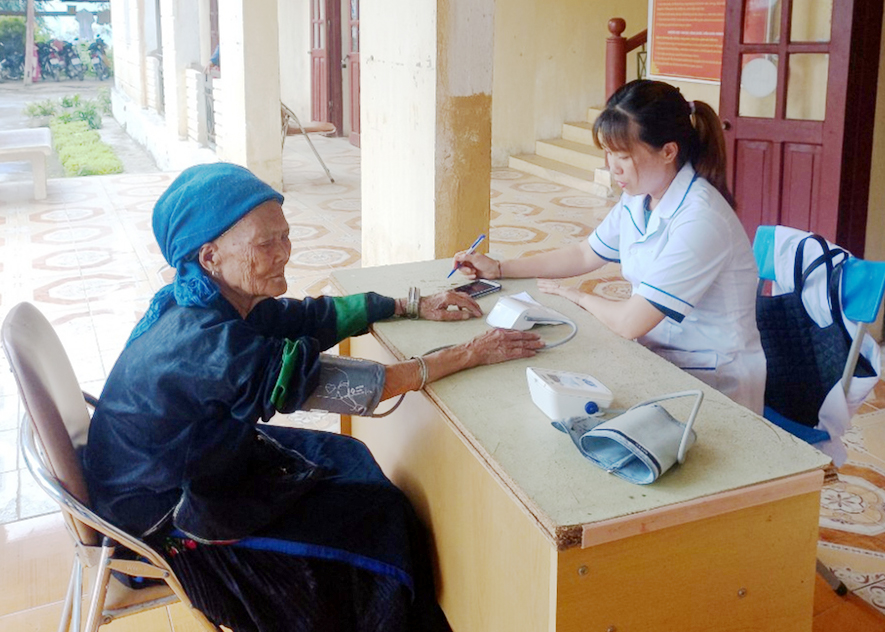 Cán bộ Trung tâm Y tế huyện Xín Mần khám bệnh cho cụ Lù Già Lìn, sinh 1914 ở thôn Thẳm Giá, xã Tả Nhìu.