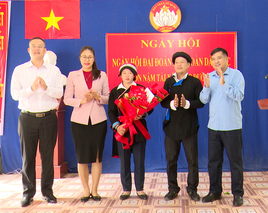 Bí thư Thành ủy Hầu Minh Lợi tặng hoa chúc mừng Ngày hội Đại đoàn kết thôn Nậm Tài. Ảnh: Bàng Cường (Tp. HG)