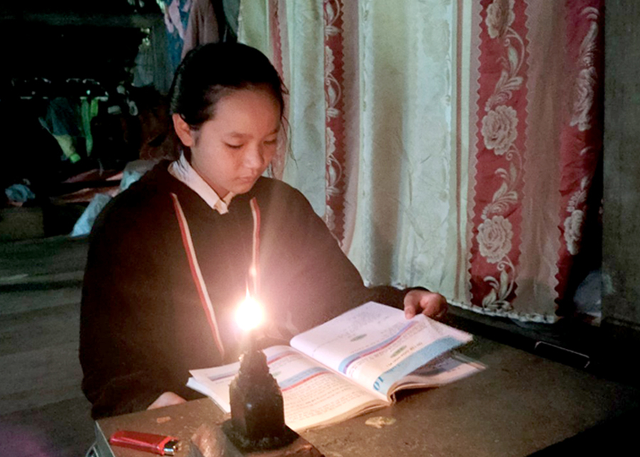 Học sinh thôn Xà Phìn, xã Phương Tiến học bài dưới ánh sáng đèn dầu.