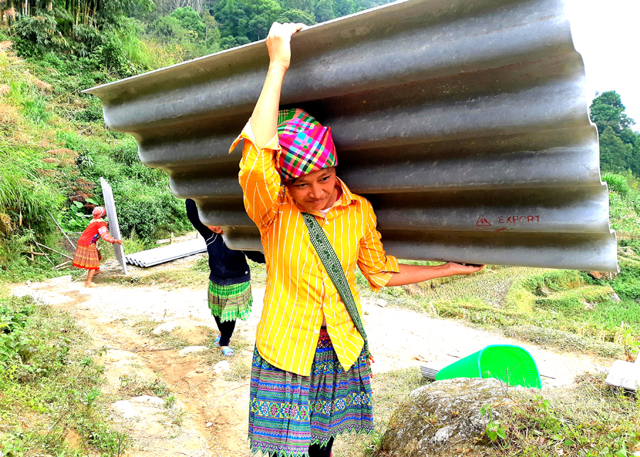 Phụ nữ thôn Gì Thàng, xã Chế Là (Xín Mần) giúp nhau vận chuyển vật liệu xây dựng nhà ở.