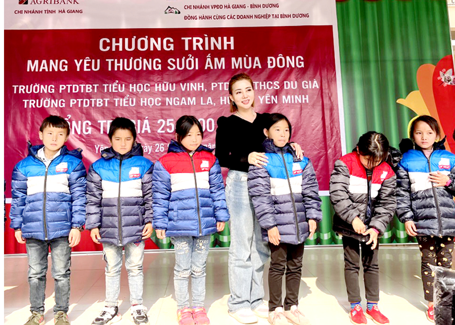 Đại diện Công ty TNHH Thương mại Vĩnh Tín Việt Nam trao áo ấm cho học sinh Trường PTDT Bán trú Tiểu học Ngam La (Yên Minh).