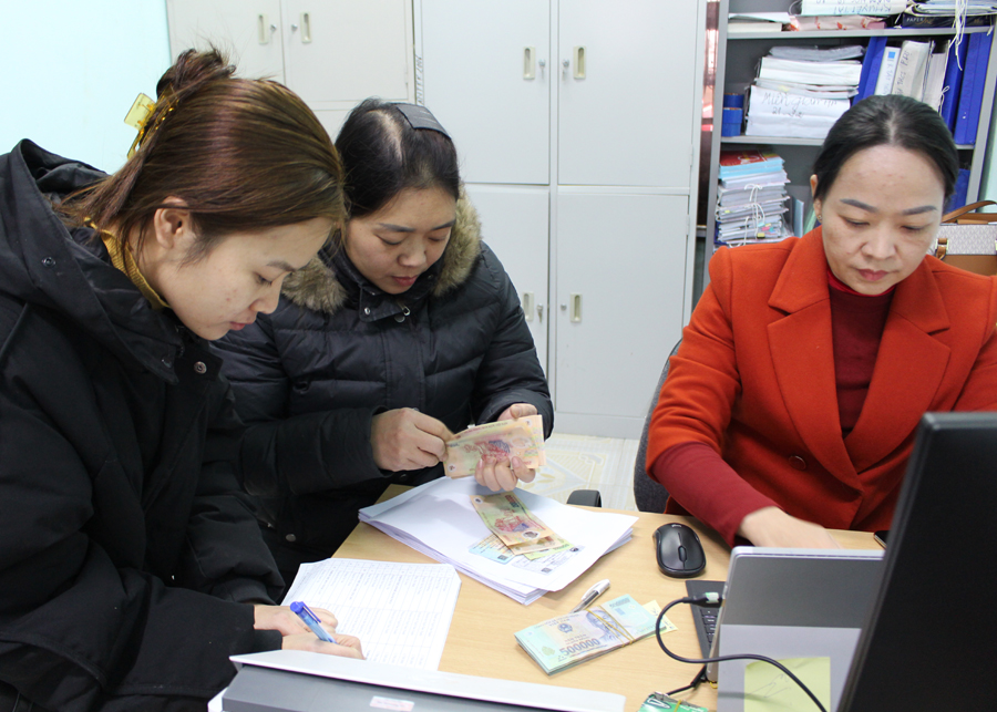 Cán bộ Phòng Giáo dục và Đào tạo thành phố Hà Giang chi trả tiền hỗ trợ Covid - 19 cho các đối tượng.
