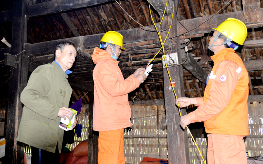 Công nhân Điện lực thành phố thay dây, bảng điện, bóng đèn mới miễn phí cho gia đình ông Hoàng Văn Yên, thôn Bản Cưởm 1.