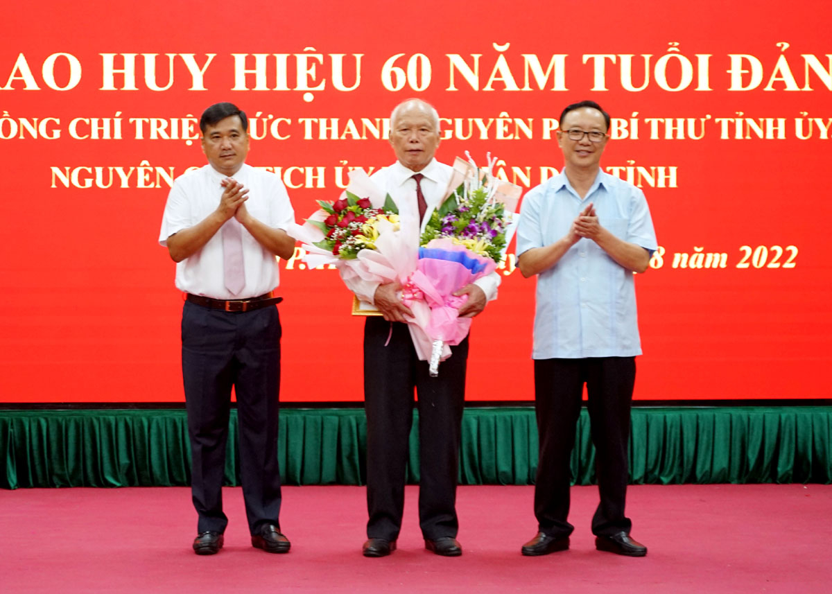 Phó Bí thư Thường trực Tỉnh ủy, Chủ tịch HĐND tỉnh Thào Hồng Sơn và Bí thư Thành ủy Hầu Minh Lợi trao Huy hiệu 60 năm tuổi Đảng cho đảng viên Triệu Đức Thanh.