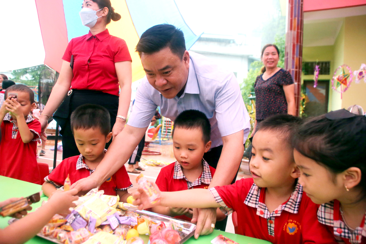 Phó Chủ tịch Thường trực UBND tỉnh Hoàng Gia Long chung vui và chia bánh kẹo cho các cháu.
