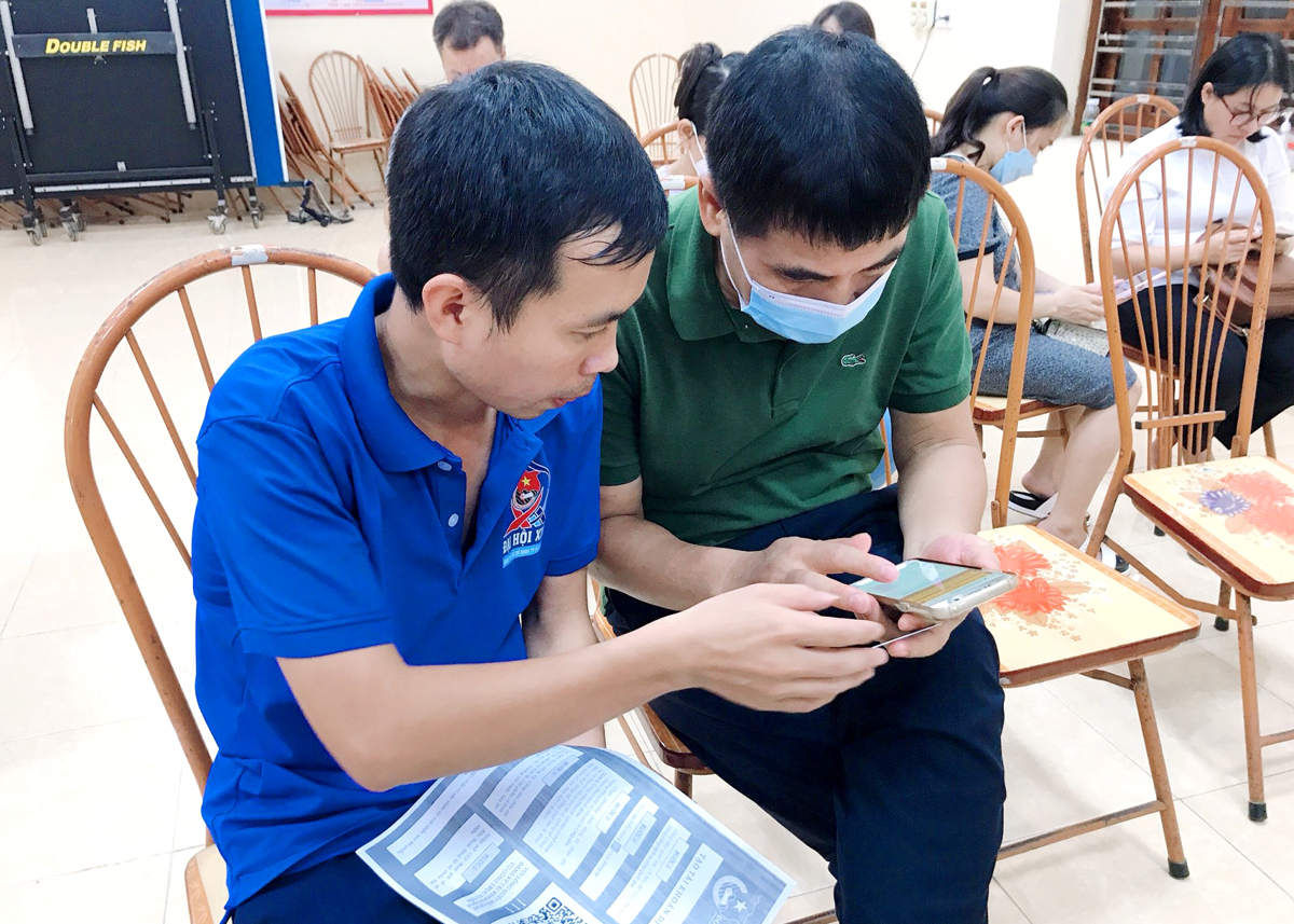Đại diện Tổ công nghệ số cộng đồng phường Minh Khai hướng dẫn nhân dân sử dụng thanh toán điện tử.
