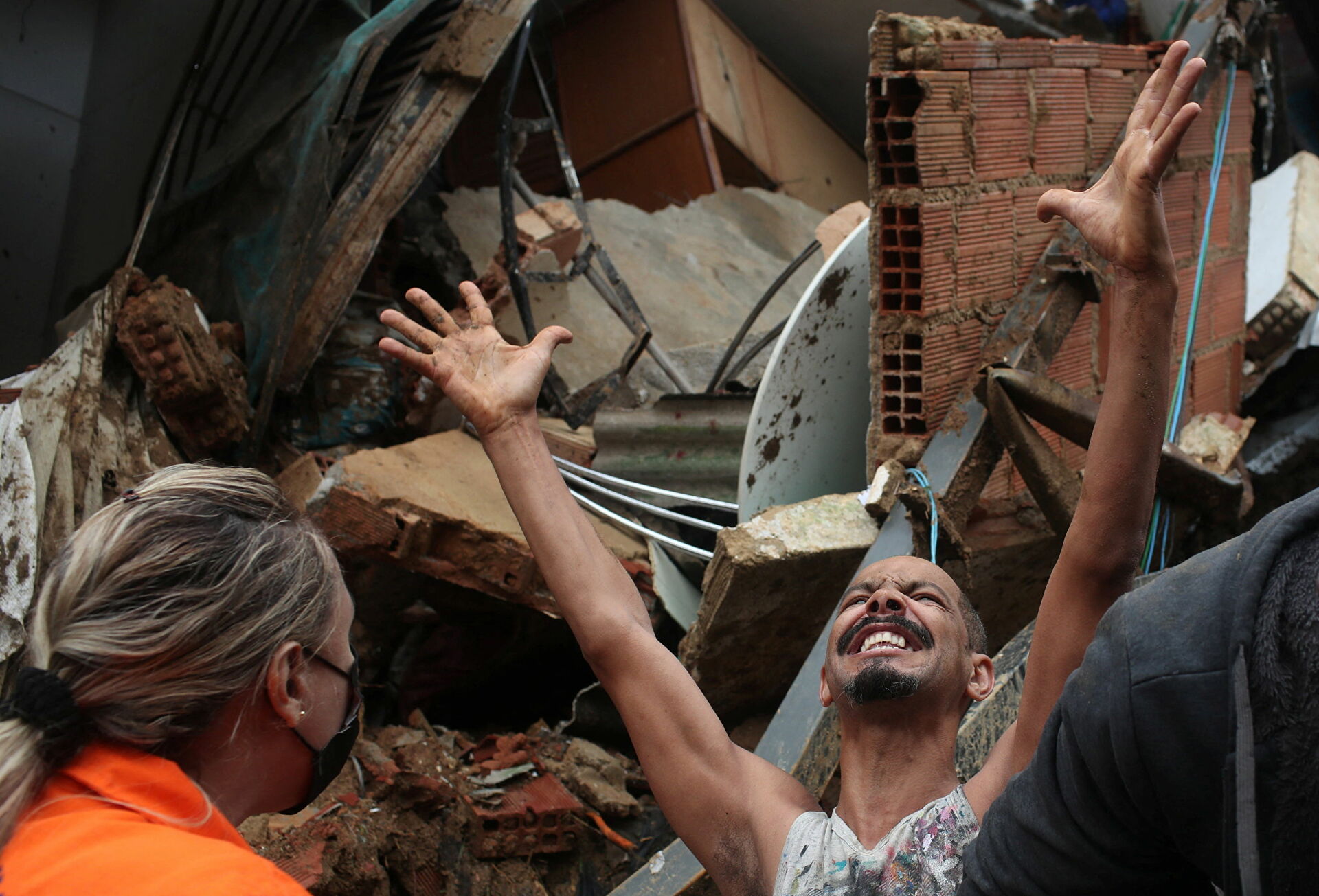 Người đàn ông tìm kiếm người thân của mình ở Morro-da-Oficina sau trận mưa lớn ở Petropolis, Brazil. 
