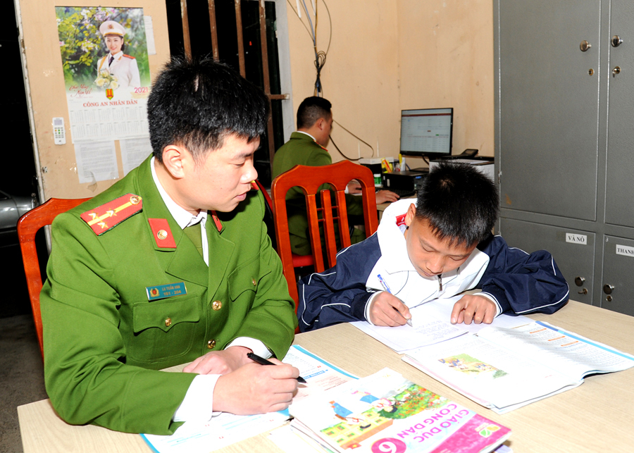 Thượng úy La Tuấn Anh - Công an xã Niêm Sơn (Mèo Vạc) dạy cháu Ly Mí Hồng học bài.

