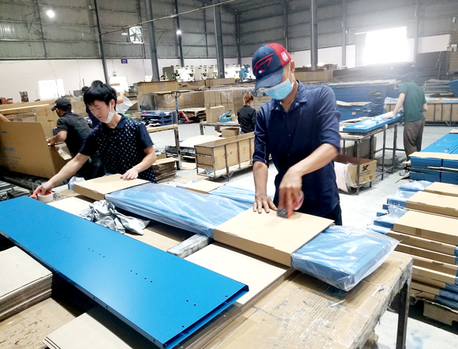 Lao động Hà Giang đóng gói sản phẩm gỗ tại Bình Dương. 
				                                   Ảnh: CTV
