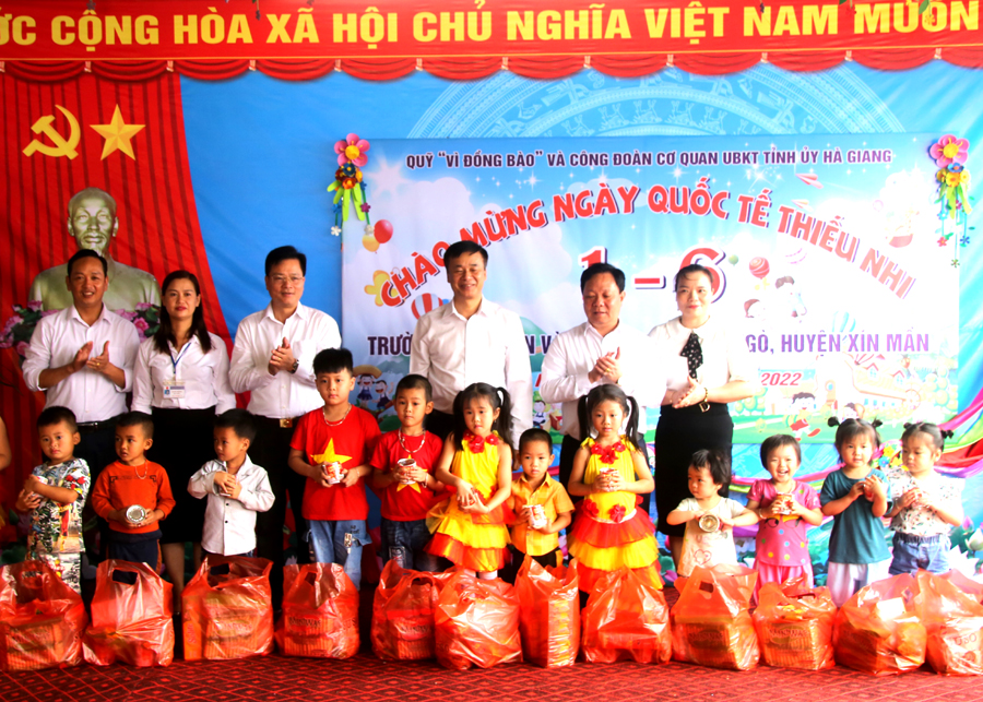 Chủ nhiệm UBKT Tỉnh ủy Trần Quang Minh và lãnh đạo huyện Xín Mần tặng quà cho học sinh xã Bản Ngò.
