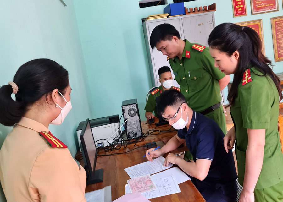 Công an huyện hướng dẫn người dân làm thủ tục đăng ký xe mô tô tại Công an xã Hùng An, huyện Bắc Quang