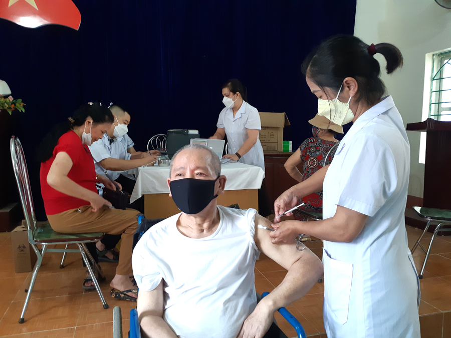 Cán bộ y tế phường Minh Khai tiêm vắc xin phòng Covid-19 mũi 4 cho người dân.