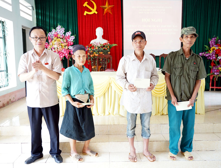 Chủ tịch HĐND tỉnh Thào Hồng Sơn tặng quà cho một số hộ nghèo trên địa bàn xã Kim Linh, huyện Vị Xuyên.
