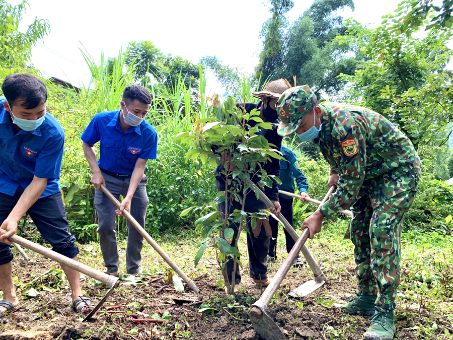 Cán bộ Đồn Biên phòng Bạch Đích giúp nhân dân cải tạo vườn tạp.
