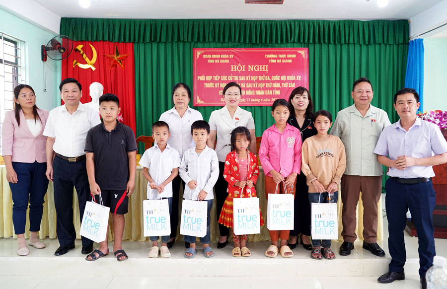 Đại diện Tập đoàn TH True milk tặng quà học sinh nghèo vượt khó trên địa bàn xã Tùng Vài (Quản Bạ).

