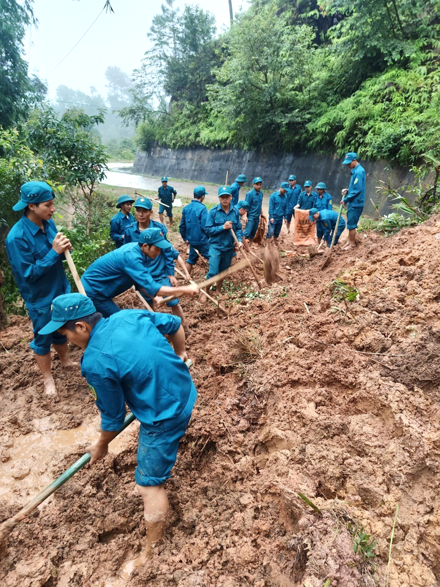 Lực lượng dân quân xã Bản Phùng đang nỗ lực khắc phục sạt lở tại một tuyến đường địa bàn