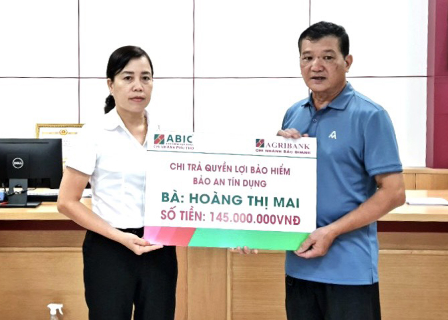 Bà Đào Thị Tâm- Phó Giám đốc Agribank Chi nhánh Bắc Quang trao chi trả quyền lợi Bảo an tín dụng cho đại diện gia đình bà Hoàng Thị Mai

