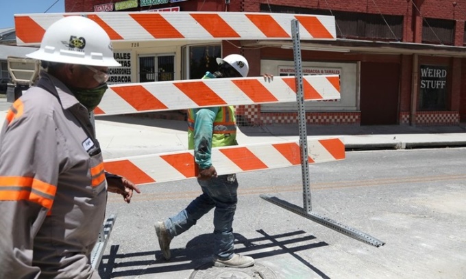 Hai công nhân làm việc dưới cảnh báo nắng nóng cao độ ở thành phố San Antonio, bang Texas, Mỹ, ngày 19/7.