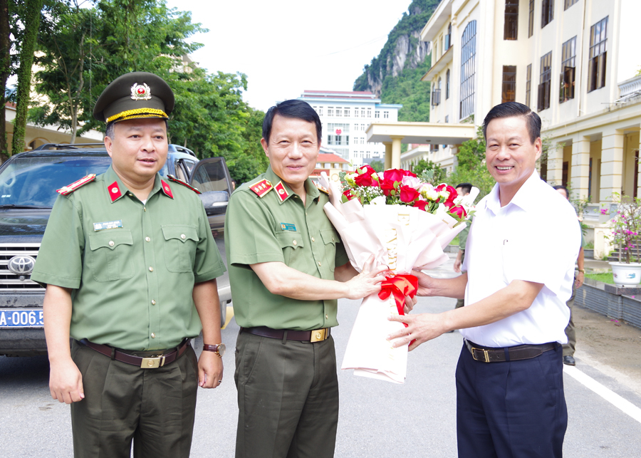 Chủ tịch UBND tỉnh Nguyễn Văn Sơn tặng hoa chào mừng Thứ trưởng Bộ Công an Lương Tam Quang làm việc tại Công an tỉnh.
