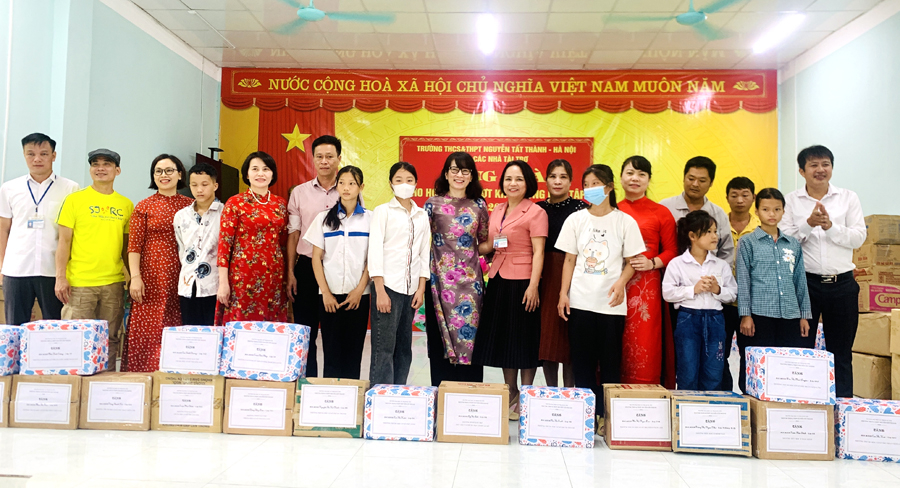 Đại diện các đơn vị tặng sách giáo khoa và đồ dùng học tập cho học sinh huyện Vị Xuyên.

