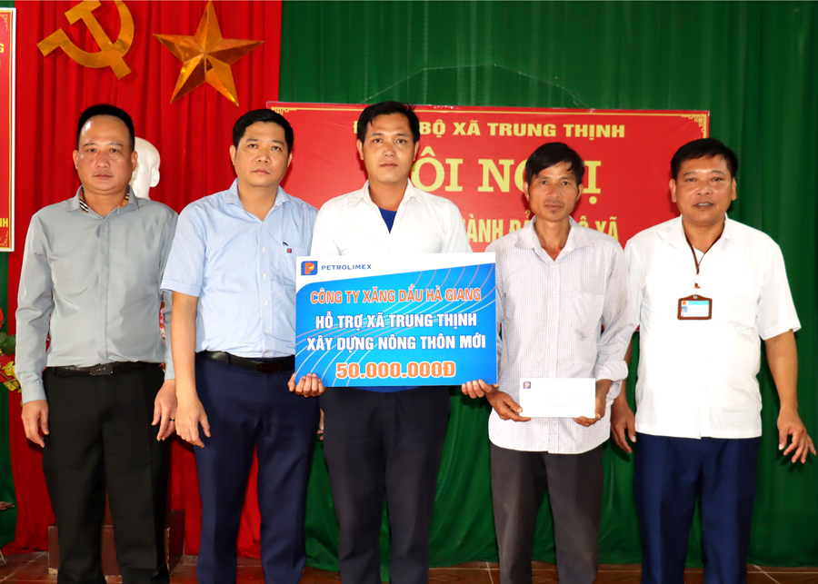 Ông Nguyễn Tiến Dũng (thứ 2 bên trái), Giám đốc Công ty Xăng dầu Hà Giang trao kinh phí hỗ trợ xây dựng nhà văn hoá thôn cho xã Trung Thịnh.
