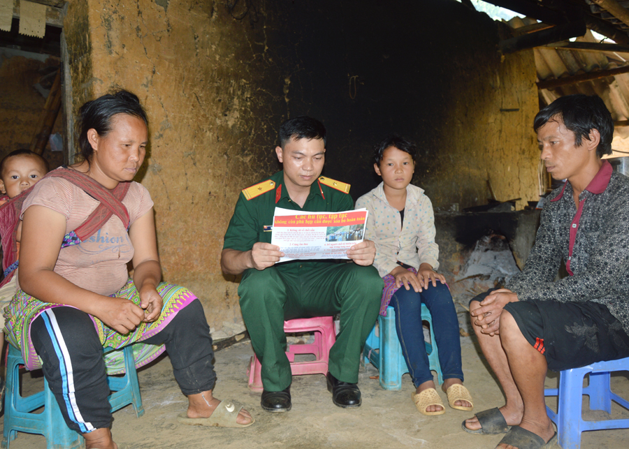 Cán bộ Ban CHQS huyện Xín Mần tuyên truyền người dân vùng đặc biệt khó khăn xóa bỏ hủ tục.
