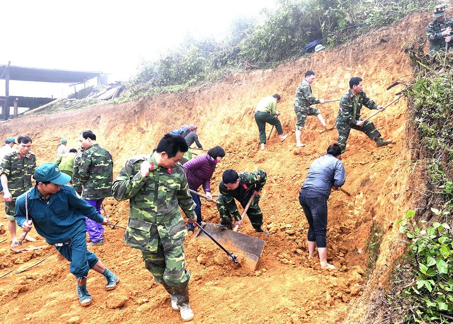 Cán bộ, chiến sỹ huyện Hoàng Su Phì giúp người dân san nền, làm nhà ở.
