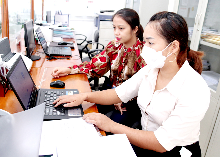 Cán bộ bộ phận một cửa huyện Bắc Quang hướng dẫn người dân tạo tài khoản dịch vụ công trực tuyến.

