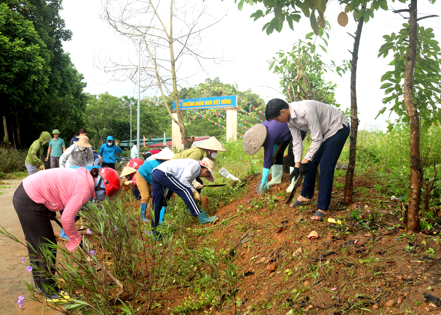Cán bộ, nhân dân xã Việt Hồng (Bắc Quang) tham gia lao động cộng sản làm sạch đường quê. 				Ảnh: HOÀNG NGỌC
