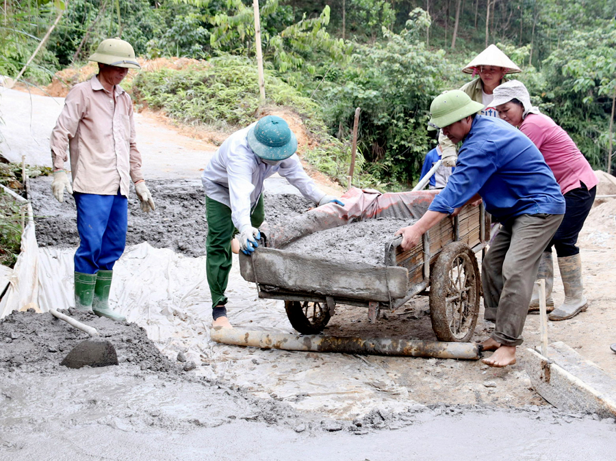 Người dân xã Quang Minh (Bắc Quang) chung tay làm đường bê tông theo chương trình xây dựng Nông thôn mới. 			Ảnh: KIM TIẾN
