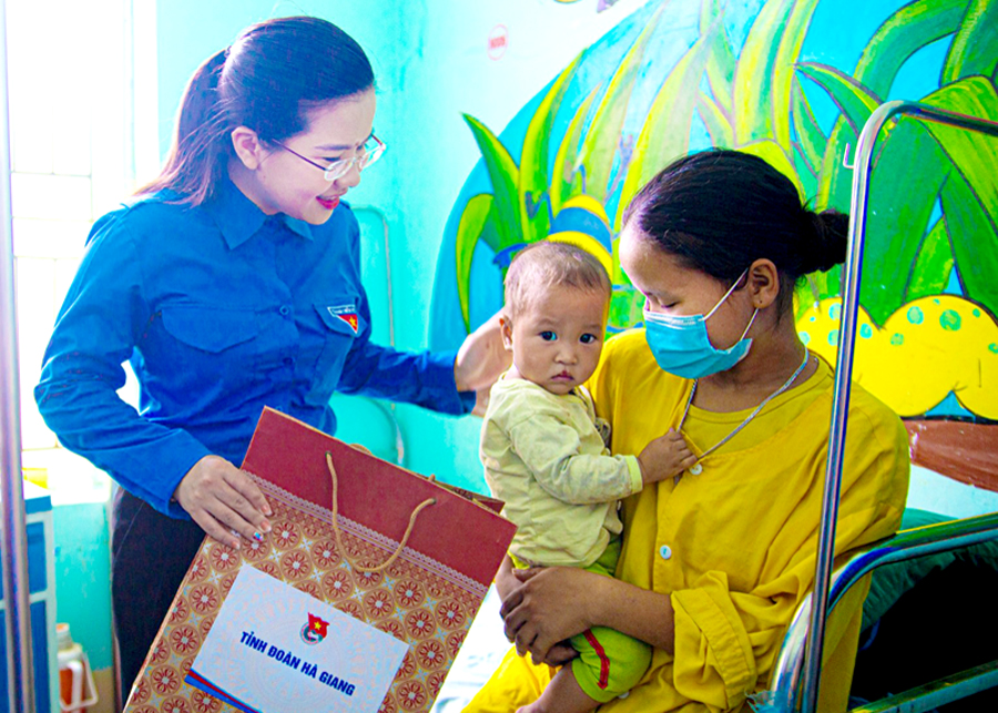 Bí thư Tỉnh đoàn Đỗ Thị Hương thăm hỏi, tặng quà bệnh nhi tại Bệnh viện Đa khoa huyện Xín Mần. 				Ảnh: CTV