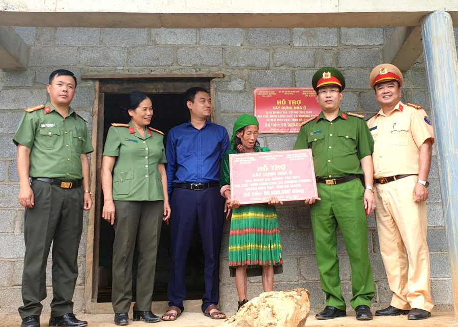 Lãnh đạo Công an tỉnh và đại diện Phòng CSGT bàn giao nhà cho gia đình bà Sùng Thị Say.
