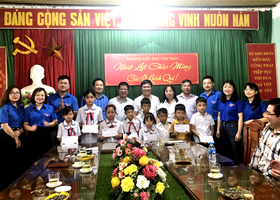 Lãnh đạo 2 cơ quan và đoàn viên thanh niên trao quà cho học sinh nghèo vượt khó tại Trường Tiểu học Tân Trào.
