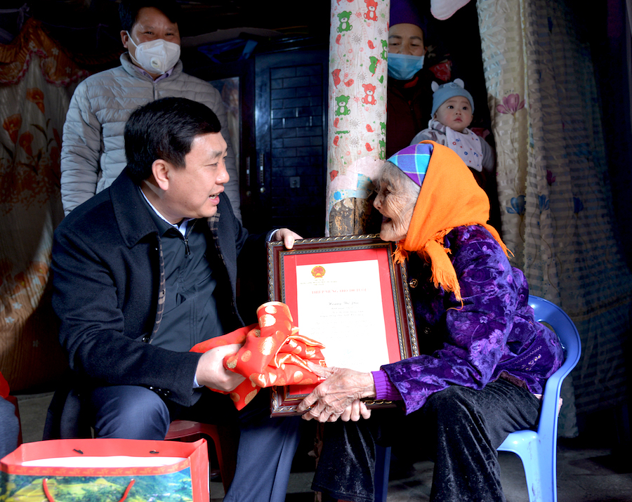 Phó Bí thư Tỉnh ủy Nguyễn Mạnh Dũng trao quà của Chủ tịch nước cho cụ già 100 tuổi tại thị trấn Đồng Văn