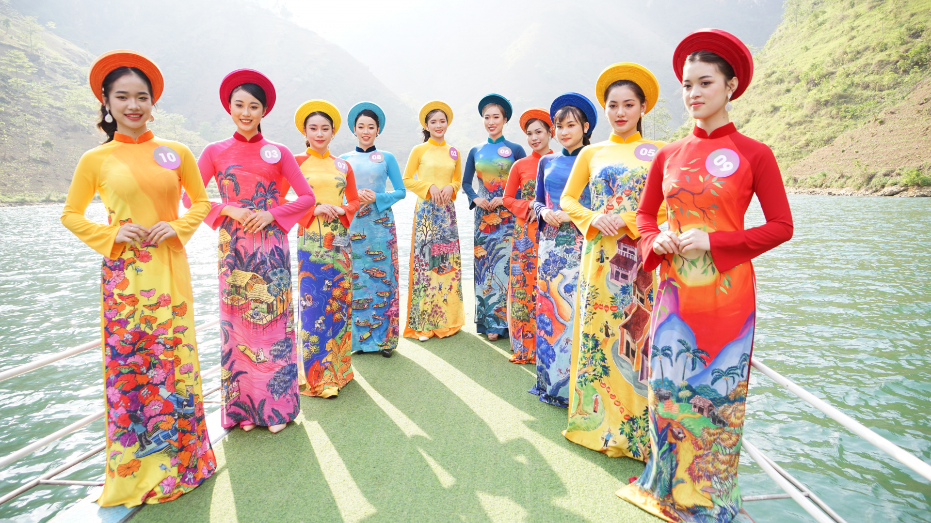 Các thí sinh chụp ảnh trong trang phục áo dài truyền thống trên dòng sông Nho Quế