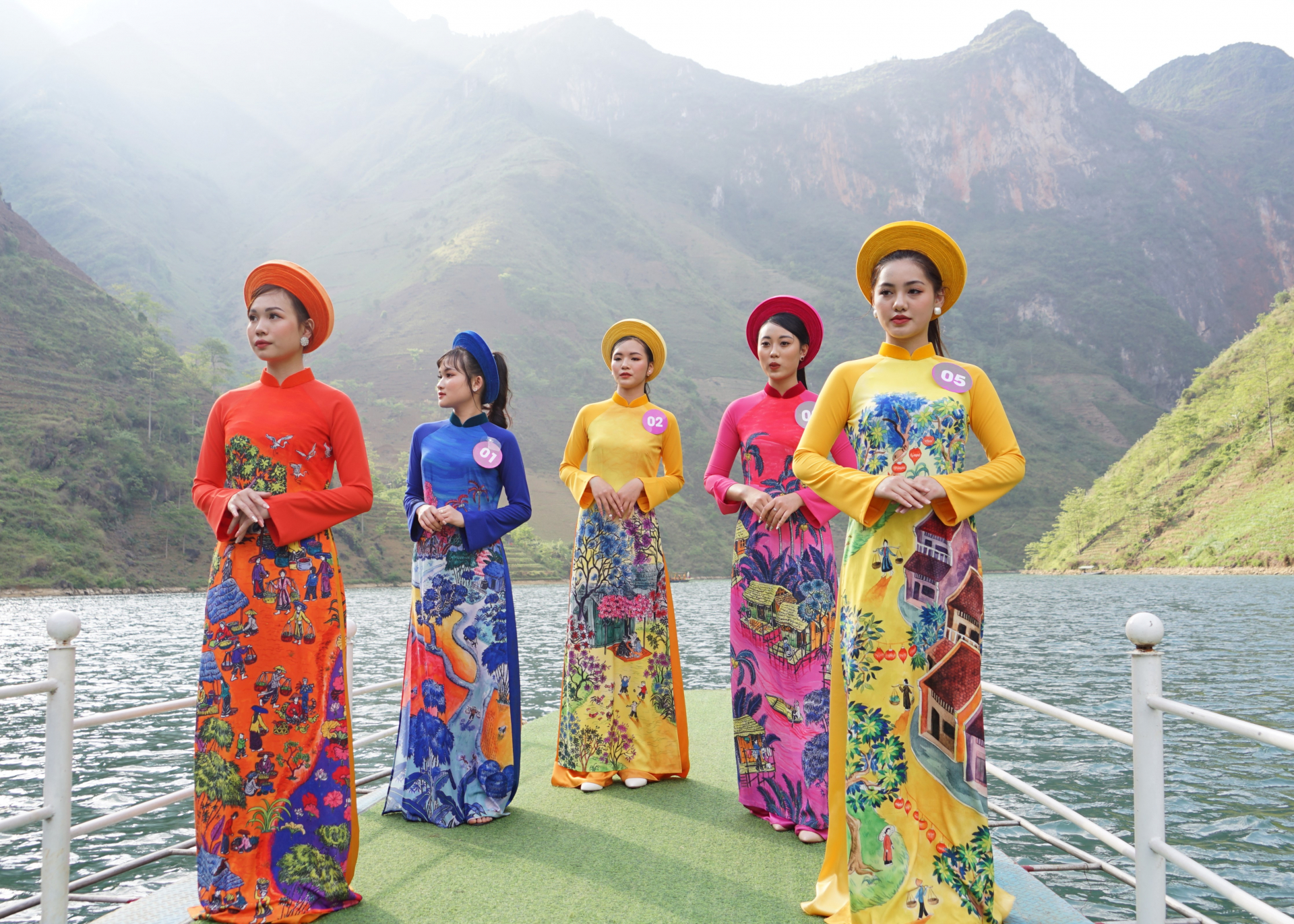 Các thí sinh chụp ảnh trong trang phục áo dài truyền thống trên dòng sông Nho Quế